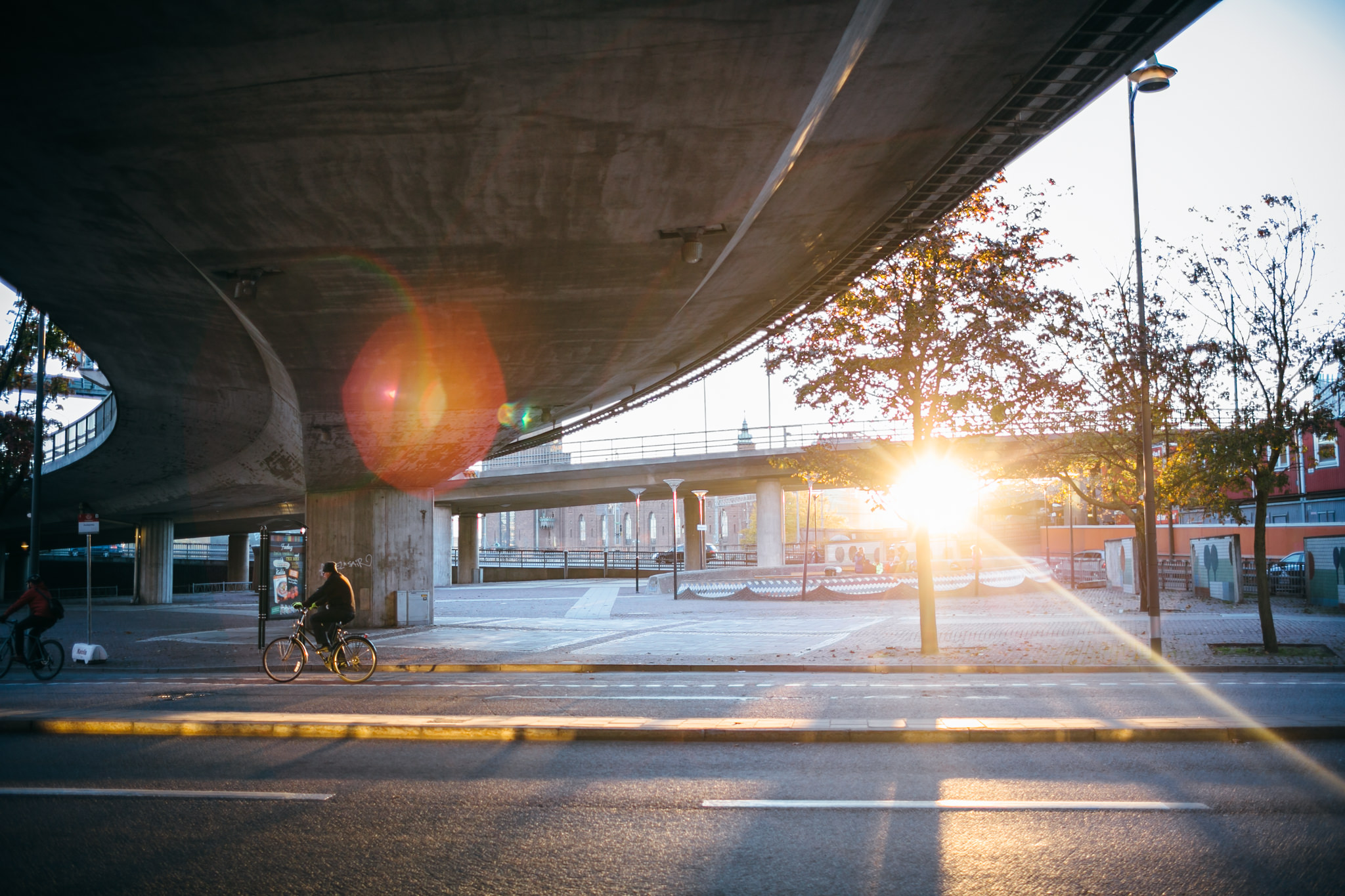 Low sun shining under a concrete bridge