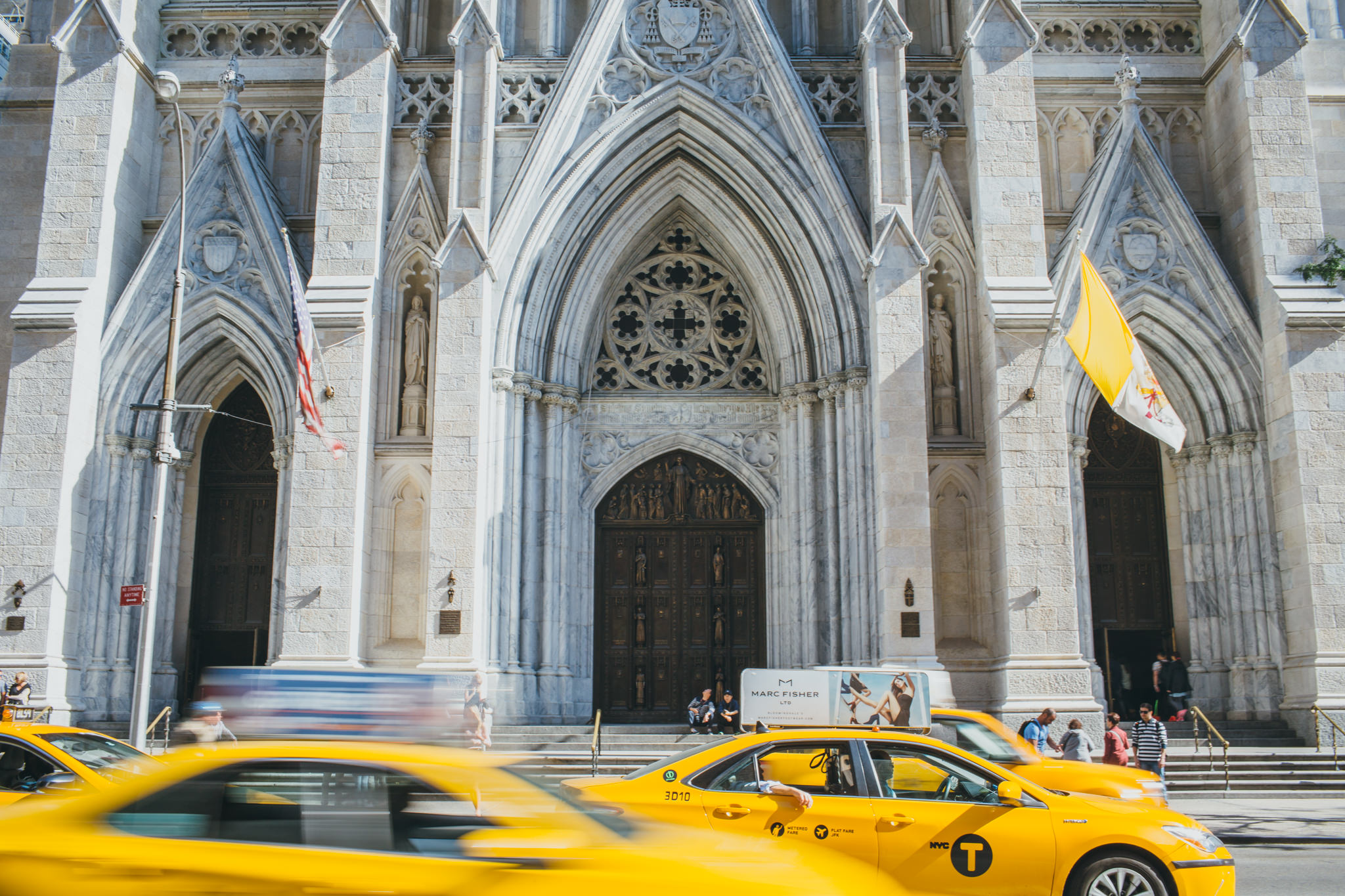Yellow taxis driving past St Patricks Church NYC