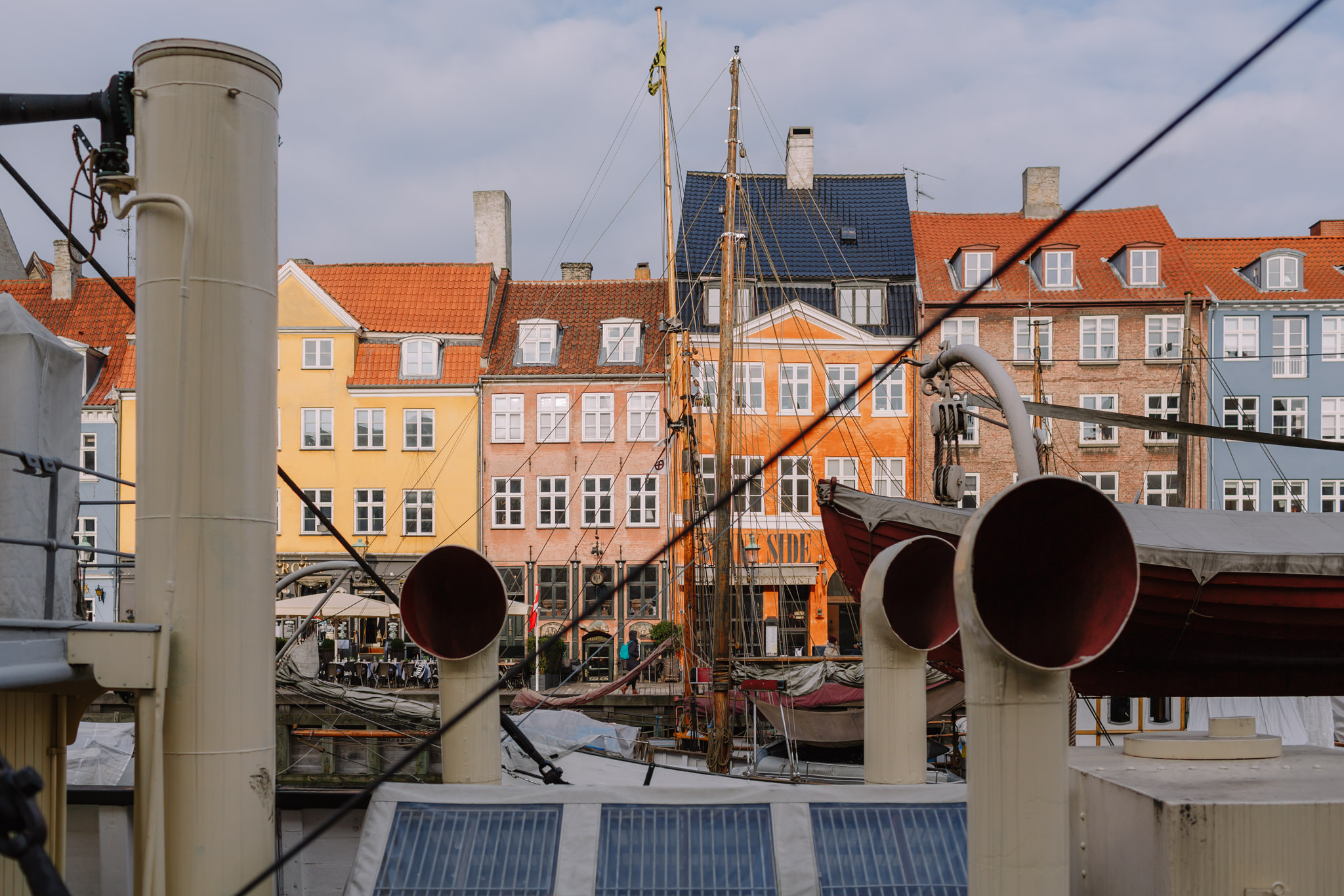 boat chimneys in front of tall colourful buildings in nyhavn